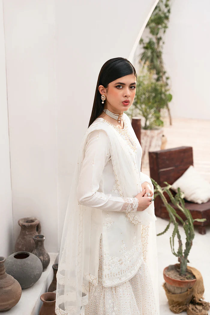 Model wearing Saira Rizwan Amaya dress, elegant white Pakistani clothes UK, detailed Eid wear.