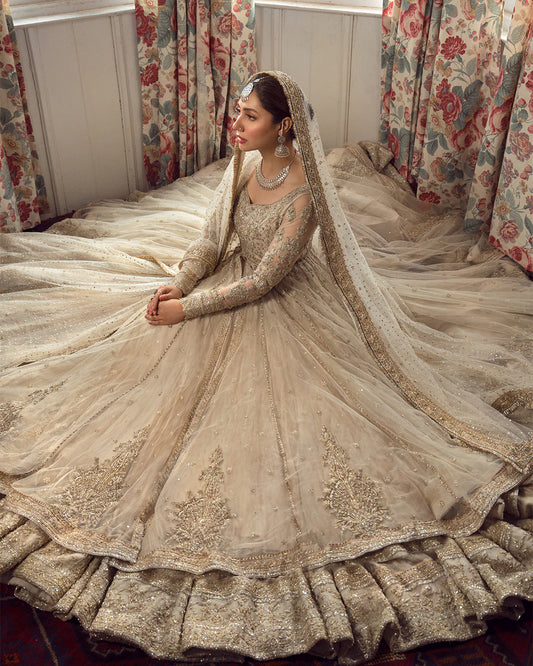 Model wearing Faiza Saqlain Anamta dress in ivory, adorned with delicate embellishments, perfect for Pakistani nikkah bridal wear available online in the UK.