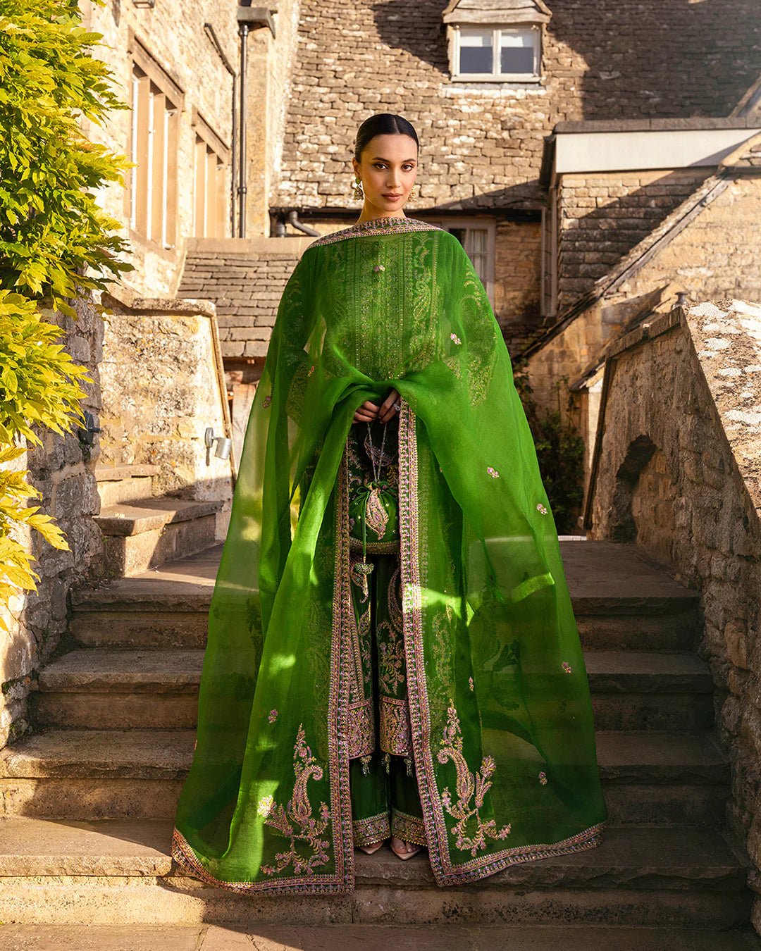 Model wearing Tegan from Faiza Saqlain's Adeen Velvet '24 collection in opulent emerald green. Luxury pret, festive, Pakistani clothes online in UK.