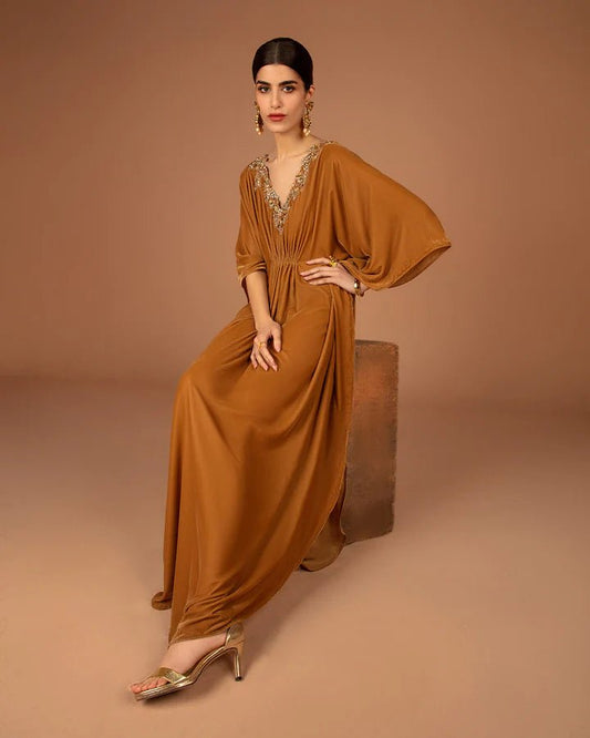 Model wearing a golden Altin dress from Faiza Saqlain's Aleira Evening Edit '24 collection. Pakistani clothes online in UK.