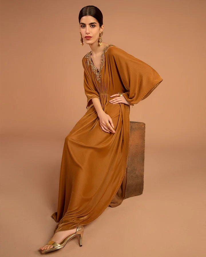 Model wearing a golden Altin dress from Faiza Saqlain's Aleira Evening Edit '24 collection. Pakistani clothes online in UK.