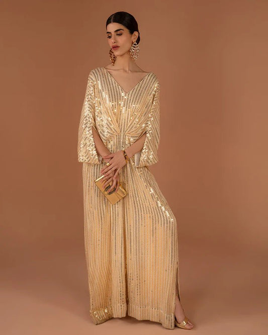 Model wearing a gold Beyza dress from Faiza Saqlain's Aleira Evening Edit '24 collection. Pakistani clothes online in UK.