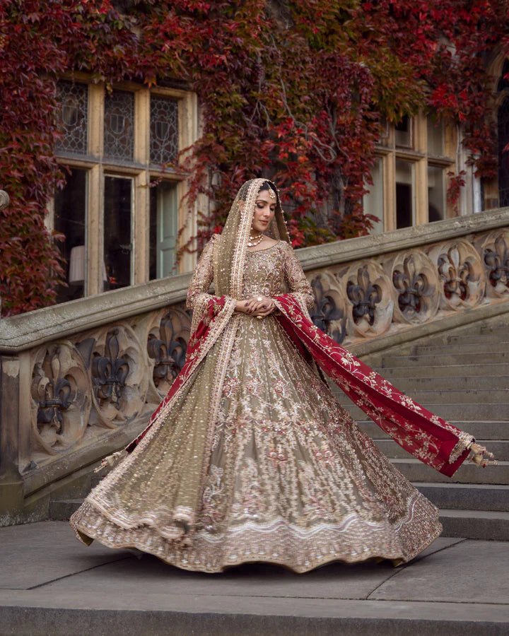 Model wearing a red and gold Ghina bridal dress by Faiza Saqlain featuring intricate embroidery, ideal for Pakistani weddings, available online in the UK.