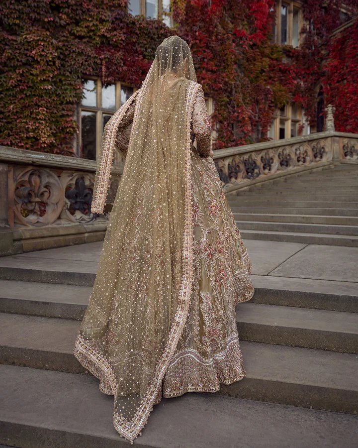 Model wearing a red and gold Ghina bridal dress by Faiza Saqlain featuring intricate embroidery, ideal for Pakistani weddings, available online in the UK.