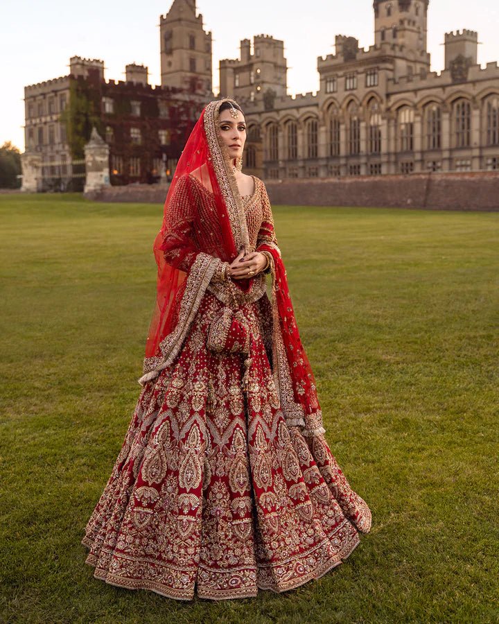 Model wearing a red Raeni bridal dress by Faiza Saqlain adorned with gold embroidery, perfect for Pakistani weddings, available online in the UK.