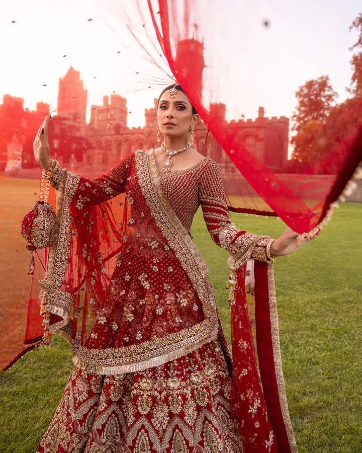 Model wearing a red Raeni bridal dress by Faiza Saqlain adorned with gold embroidery, perfect for Pakistani weddings, available online in the UK.