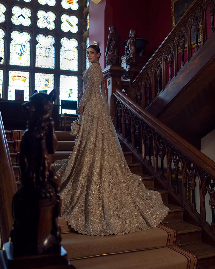 Model wearing an elegant off - white Reem bridal dress by Faiza Saqlain, featuring intricate beadwork, perfect for Pakistani weddings, available online in the UK.