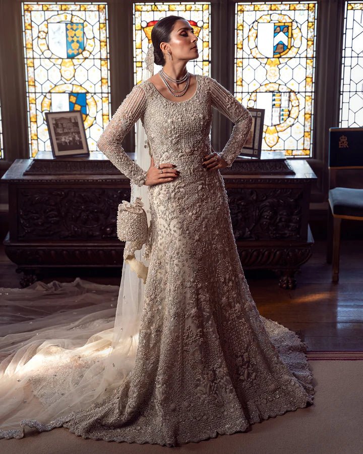 Model wearing an elegant off - white Reem bridal dress by Faiza Saqlain, featuring intricate beadwork, perfect for Pakistani weddings, available online in the UK.