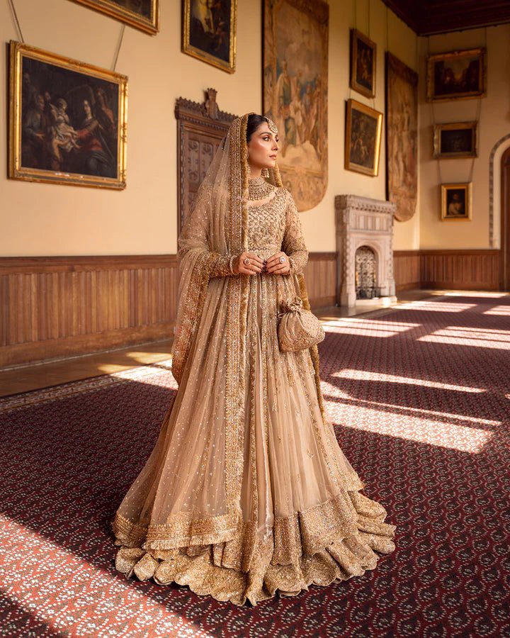 Model wearing a gold Zariana bridal dress by Faiza Saqlain, featuring intricate embellishments, perfect for Pakistani weddings, available online in the UK.