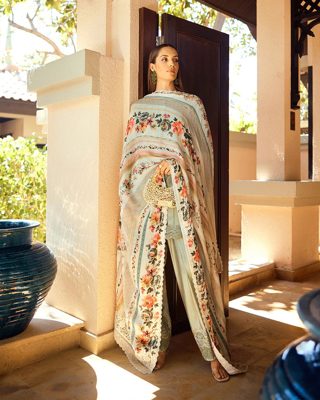 Model wearing Faiza Saqlain Carmela Arnett dress in sage green with a floral printed white dupatta. Shop Pakistani bridal dresses online in the UK now.