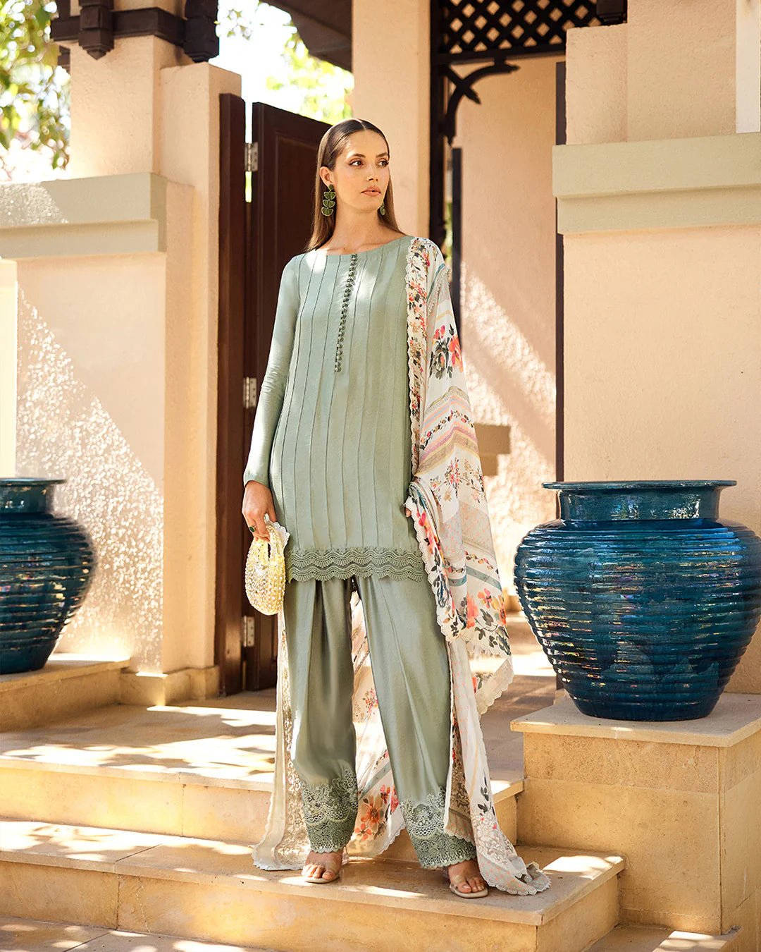 Model wearing Faiza Saqlain Carmela Arnett dress in sage green with a floral printed white dupatta. Shop Pakistani bridal dresses online in the UK now.