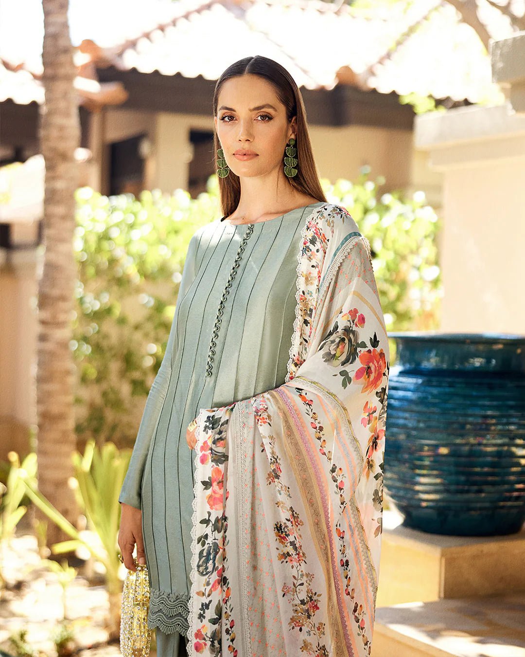 Model wearing Faiza Saqlain Carmela Arnett dress in sage green with a floral printed white dupatta. Shop Pakistani bridal dresses online in the UK now.