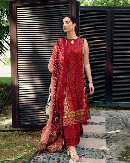 Model wearing Faiza Saqlain Carmela Gloriana dress in rich red with intricate patterns and a vibrant printed dupatta. Shop Pakistani bridal dresses online in the UK now.