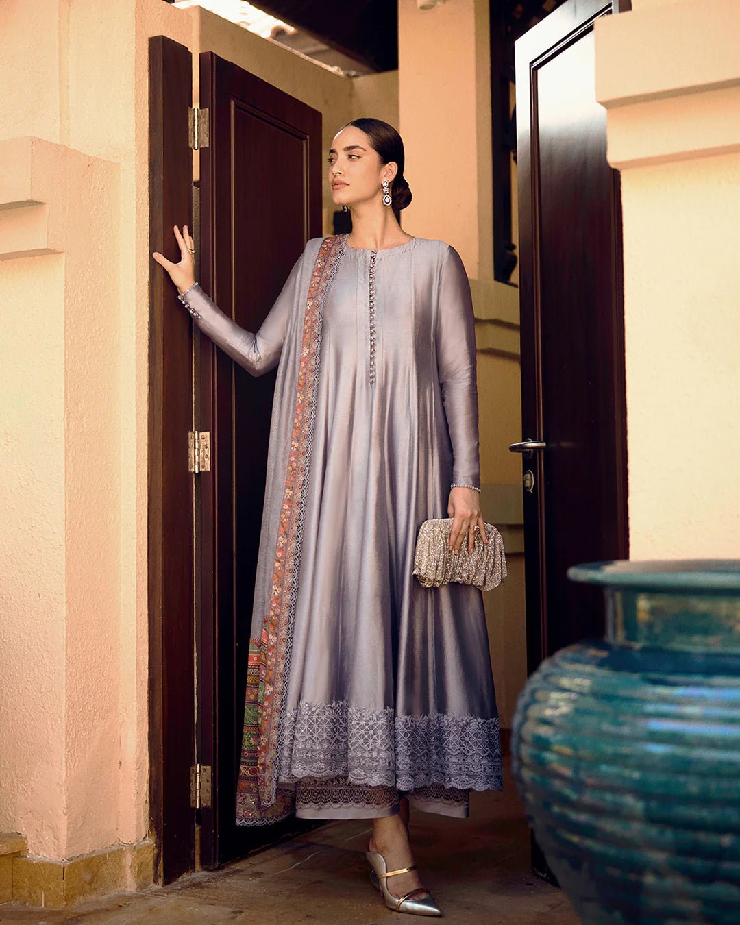 Model wearing Faiza Saqlain Carmela Mersera dress in mauve grey with intricate embroidery and a vibrant printed dupatta. Shop Pakistani bridal dresses online in the UK now.