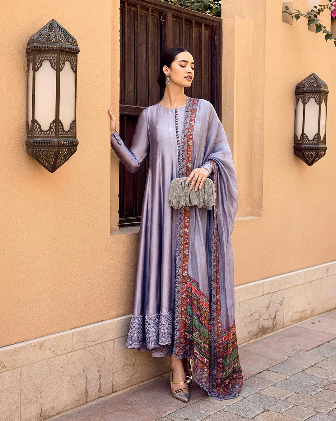 Model wearing Faiza Saqlain Carmela Mersera dress in mauve grey with intricate embroidery and a vibrant printed dupatta. Shop Pakistani bridal dresses online in the UK now.