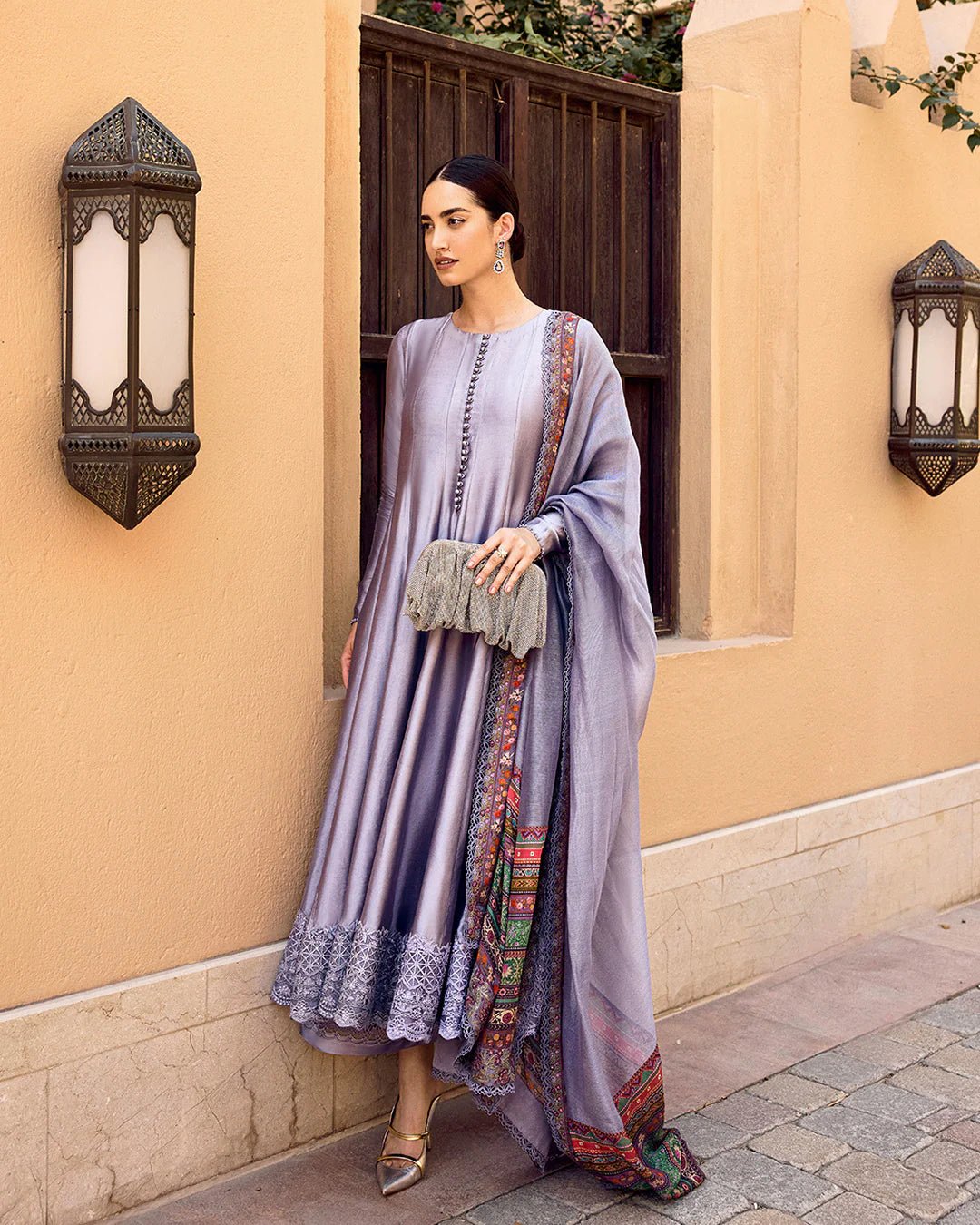 Model wearing Faiza Saqlain Carmela Mersera dress in mauve grey with intricate embroidery and a vibrant printed dupatta. Shop Pakistani bridal dresses online in the UK now.