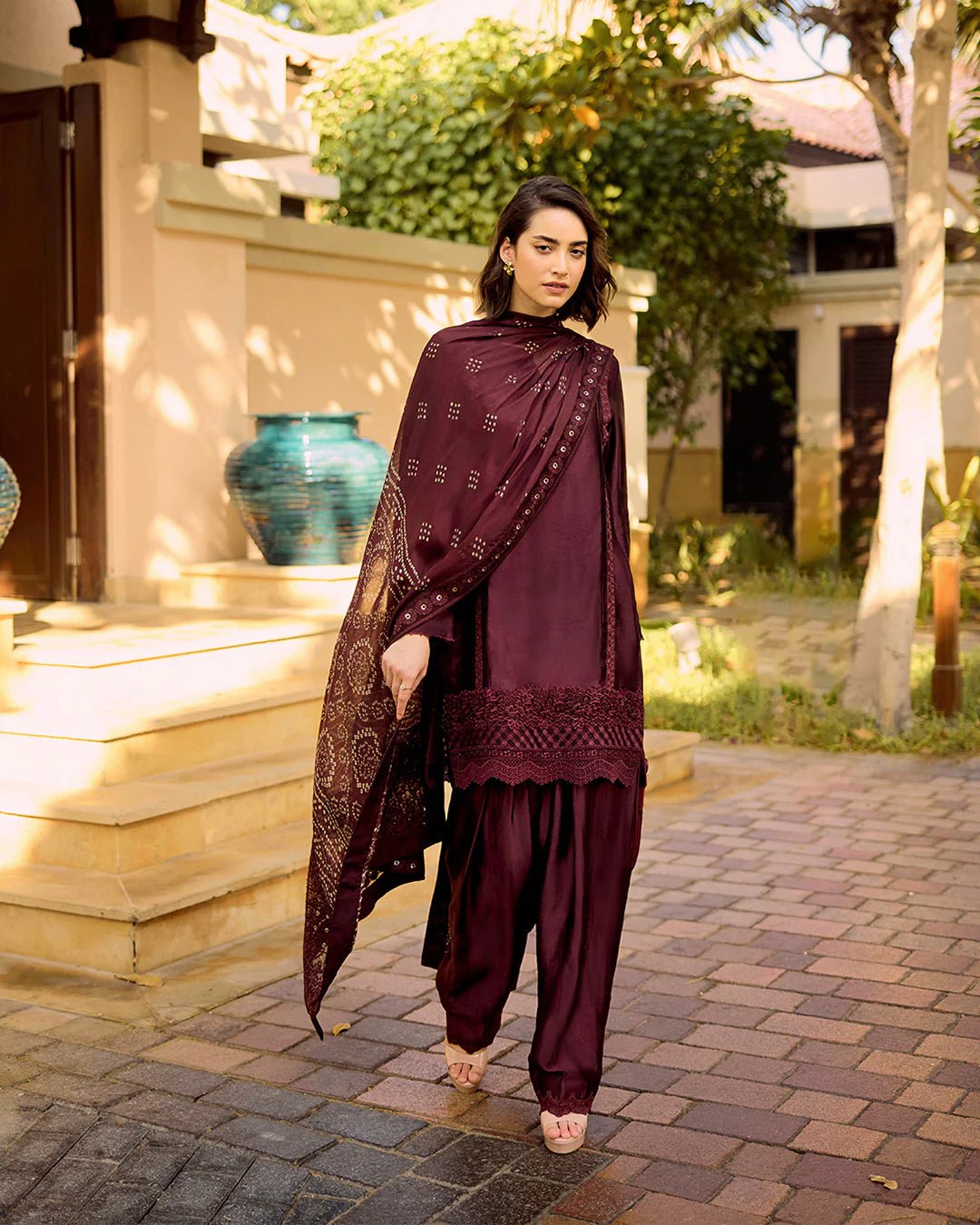 Model wearing Faiza Saqlain Carmela Triana in dark maroon with intricate embroidery, perfect for Pakistani bridal dresses online in UK.