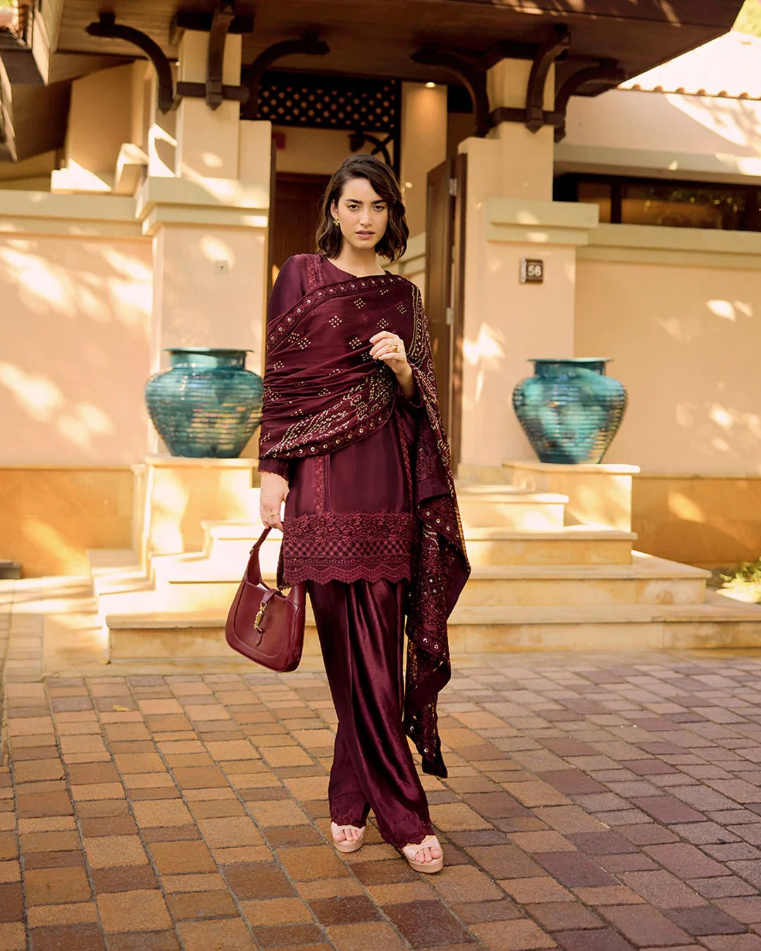 Model wearing Faiza Saqlain Carmela Triana in dark maroon with intricate embroidery, perfect for Pakistani bridal dresses online in UK.