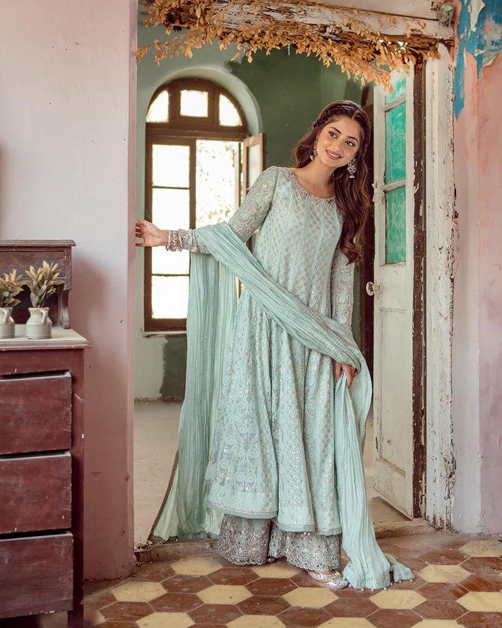 Model wearing Faiza Saqlain Naaz dress in soft blue from the Dhoop Kinaray Formals collection, perfect for weddings, available for Pakistani clothes online in the UK.