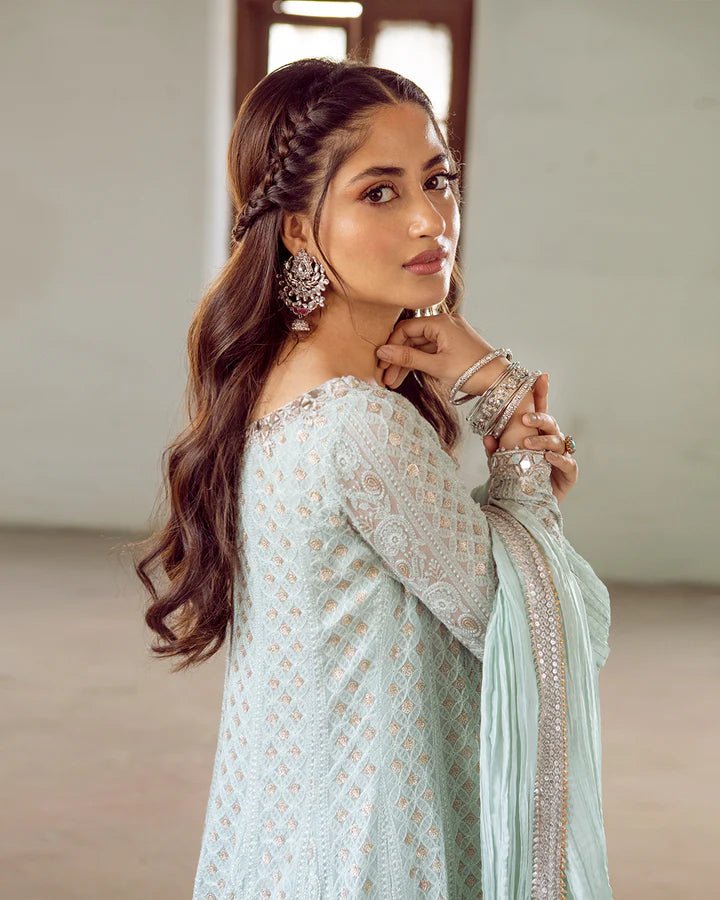 Model wearing Faiza Saqlain Naaz dress in soft blue from the Dhoop Kinaray Formals collection, perfect for weddings, available for Pakistani clothes online in the UK.