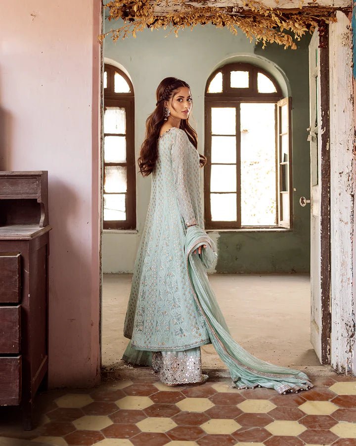 Model wearing Faiza Saqlain Naaz dress in soft blue from the Dhoop Kinaray Formals collection, perfect for weddings, available for Pakistani clothes online in the UK.