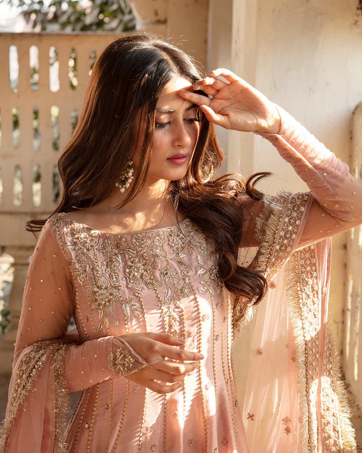 Model wearing Faiza Saqlain Nazmin dress in soft pink from the Dhoop Kinaray Formals collection, perfect for weddings, available for Pakistani clothes online in the UK.