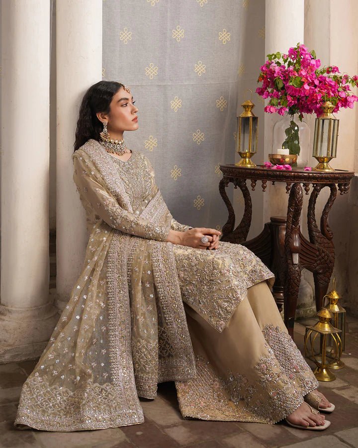 Model wearing Faiza Saqlain Formals Irina Aurela dress in Dull Gold, Pakistani clothes online in UK.