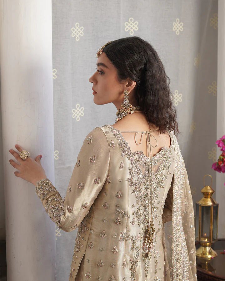 Model wearing Faiza Saqlain Formals Irina Aurela dress in Dull Gold, Pakistani clothes online in UK.