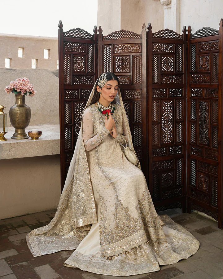 Model wearing a cream Elvana dress with intricate embellishments from Faiza Saqlain's Aleira Evening Edit '24 collection. Pakistani clothes online in UK.