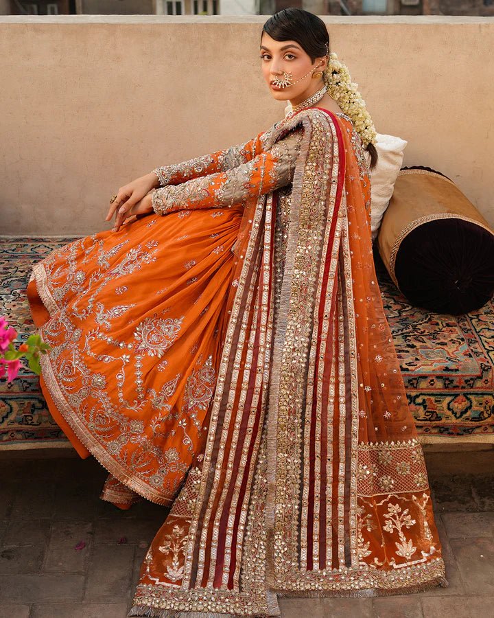 Model wearing Faiza Saqlain Formals Irina Oct '23 Sevgi dress in orange gold, Pakistani clothes online in UK.