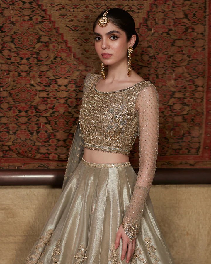 Model wearing a golden Delal dress with intricate details, part of Faiza Saqlain's Formals Sanaz collection, showcasing elegant Pakistani clothes online in the UK.