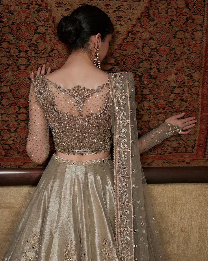 Model wearing a golden Delal dress with intricate details, part of Faiza Saqlain's Formals Sanaz collection, showcasing elegant Pakistani clothes online in the UK.