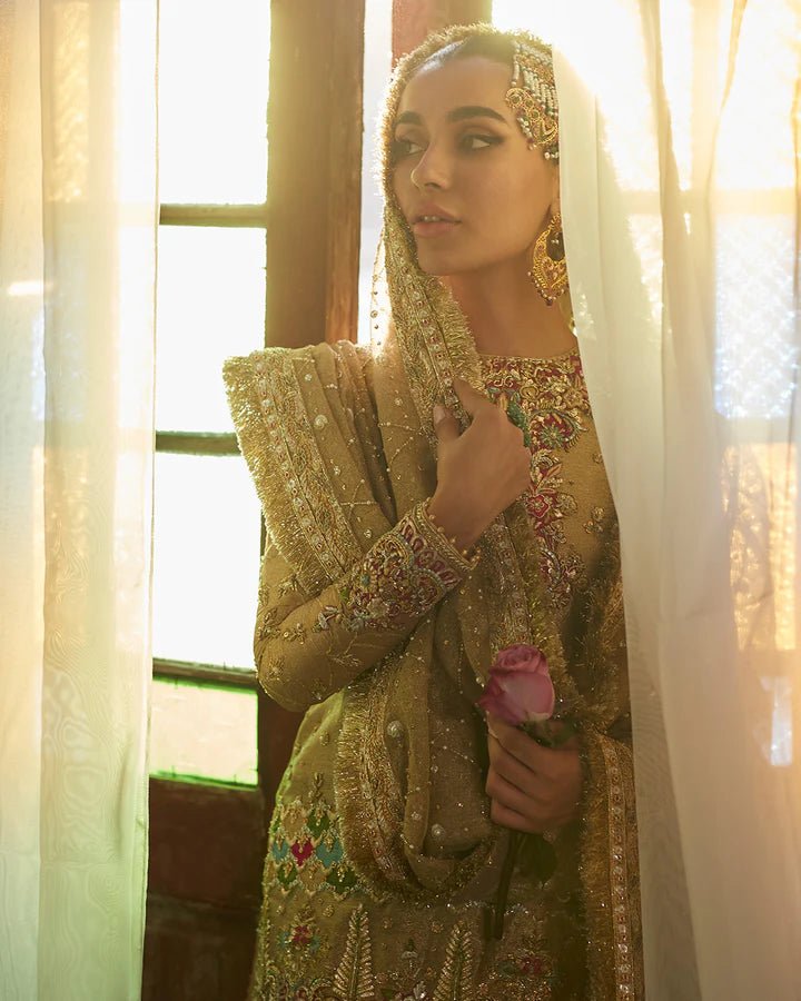 Model wearing a golden Gurleen dress with intricate red embroidery from Faiza Saqlain's Formals Sanaz collection, showcasing Pakistani clothes online in the UK.