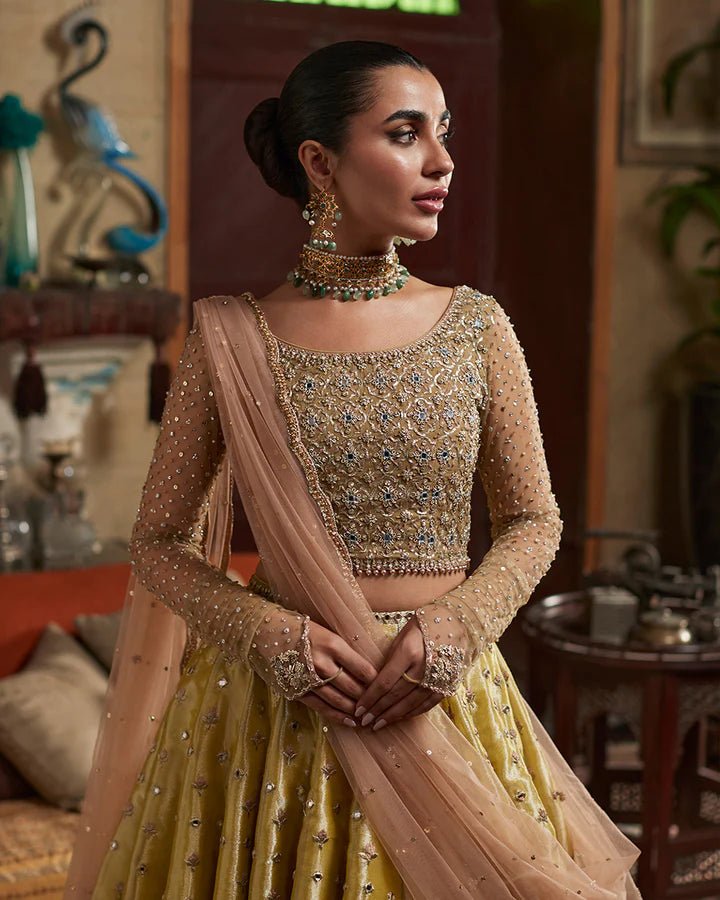 Model wearing a gold Nehal dress with intricate embellishments from Faiza Saqlain's Aleira Evening Edit '24 collection. Pakistani clothes online in UK.