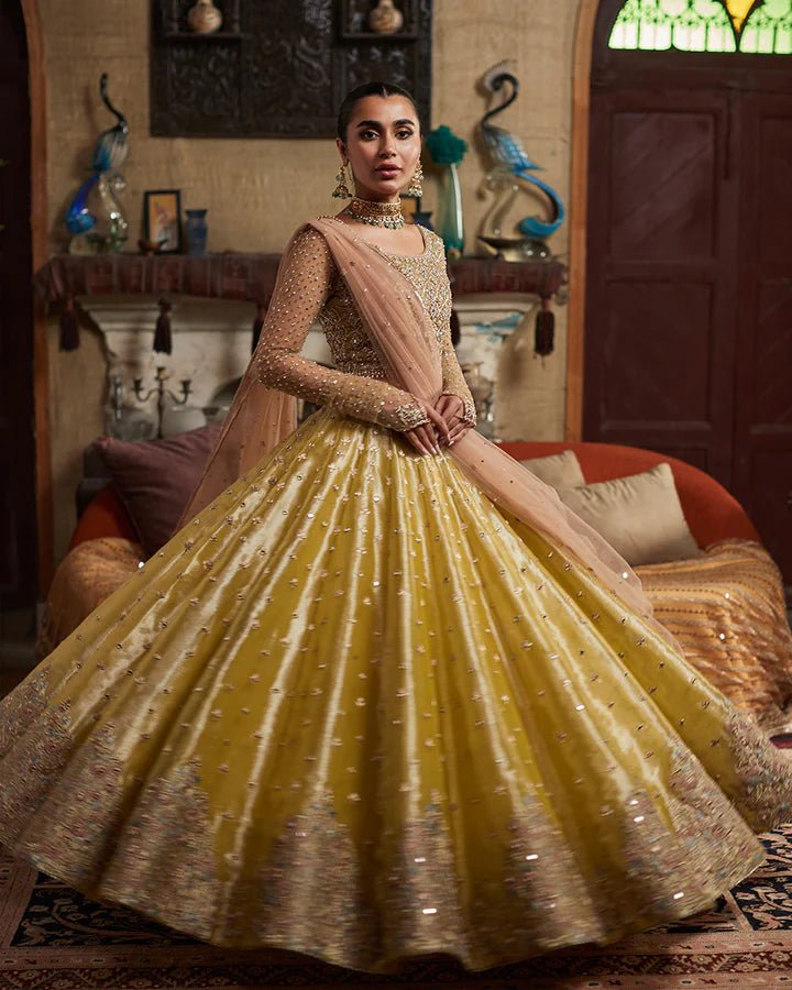 Model wearing a gold Nehal dress with intricate embellishments from Faiza Saqlain's Aleira Evening Edit '24 collection. Pakistani clothes online in UK.