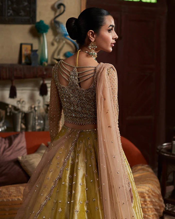 Model wearing a gold Nehal dress with intricate embellishments from Faiza Saqlain's Aleira Evening Edit '24 collection. Pakistani clothes online in UK.