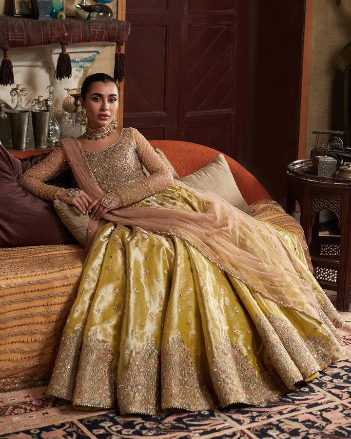 Model wearing a gold Nehal dress with intricate embellishments from Faiza Saqlain's Aleira Evening Edit '24 collection. Pakistani clothes online in UK.