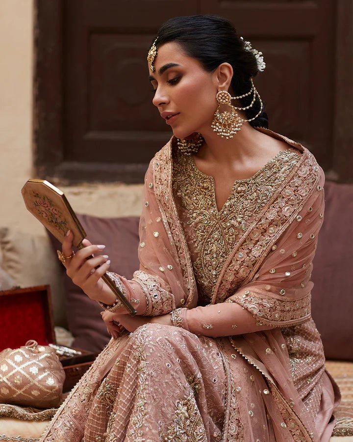 Model wearing Faiza Saqlain Formals Sanaz Zeena, a soft pink embroidered formal dress with intricate details, perfect for weddings. Available as Pakistani clothes online in the UK.