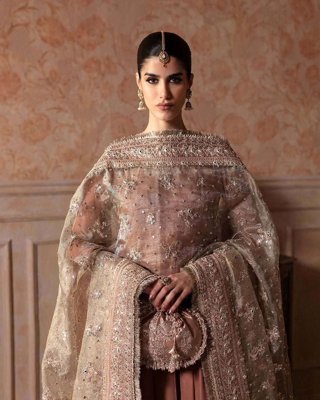 Model wearing Faiza Saqlain Ismene Averna dress in dusty rose with intricate silver embroidery and embellished dupatta. Shop Pakistani bridal dresses online in the UK now.