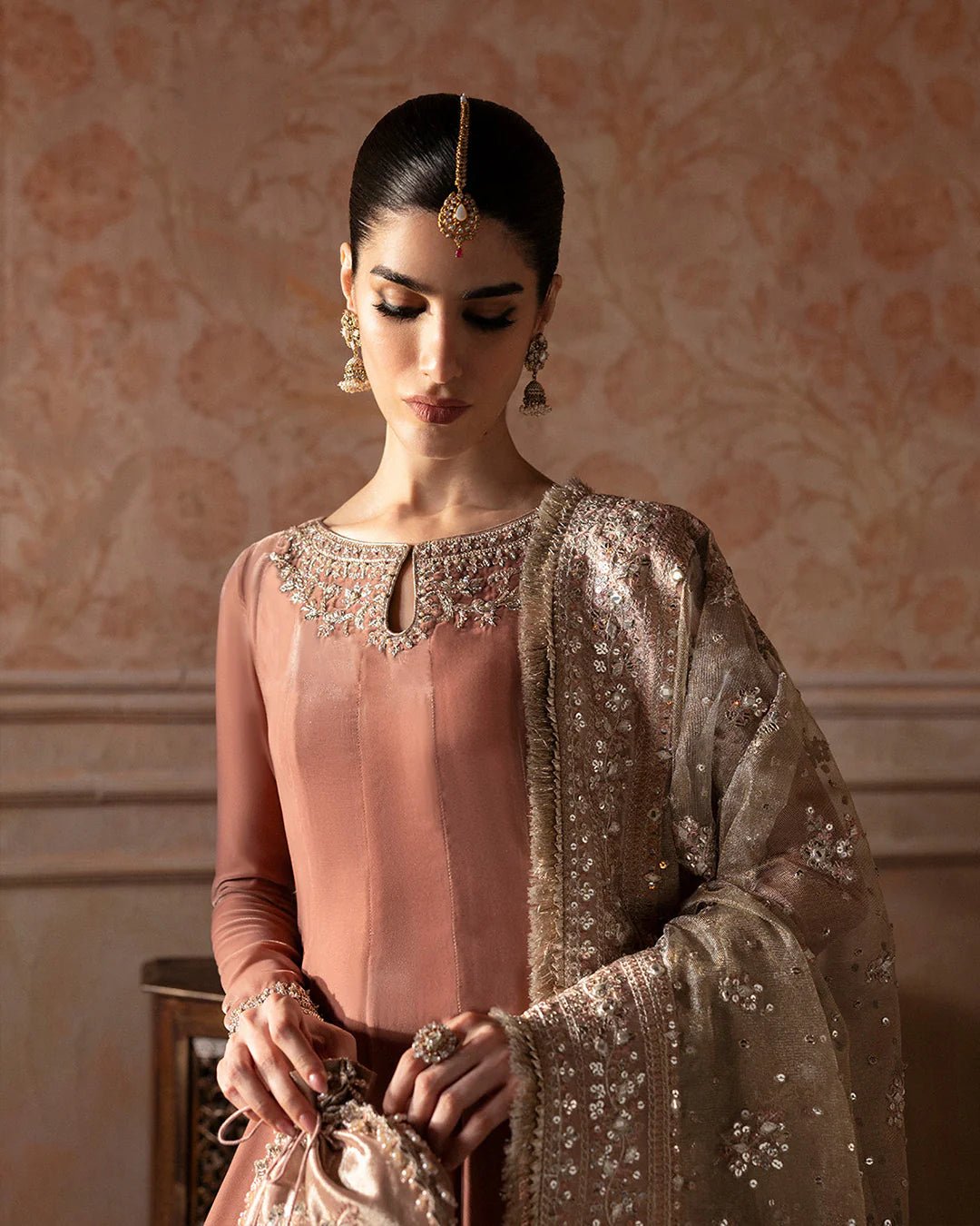 Model wearing Faiza Saqlain Ismene Averna dress in dusty rose with intricate silver embroidery and embellished dupatta. Shop Pakistani bridal dresses online in the UK now.