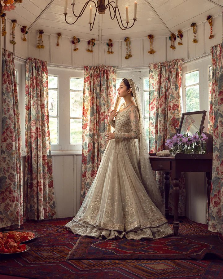 Model wearing Faiza Saqlain Anamta dress in ivory, adorned with delicate embellishments, perfect for Pakistani nikkah bridal wear available online in the UK.