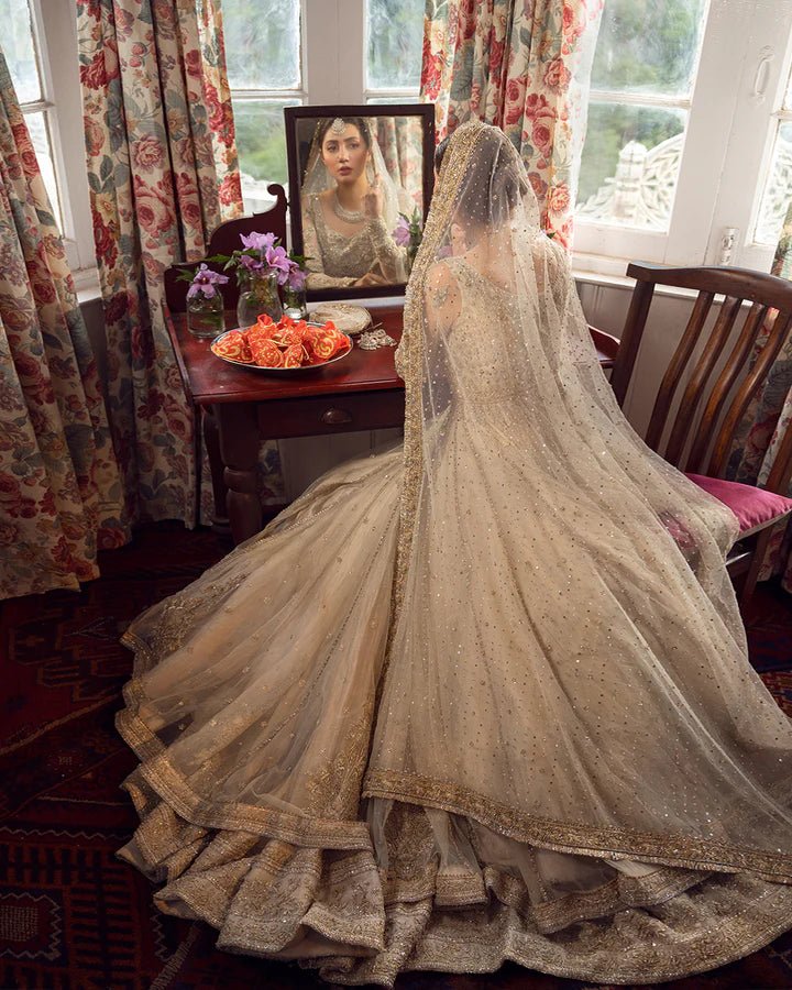 Model wearing Faiza Saqlain Anamta dress in ivory, adorned with delicate embellishments, perfect for Pakistani nikkah bridal wear available online in the UK.