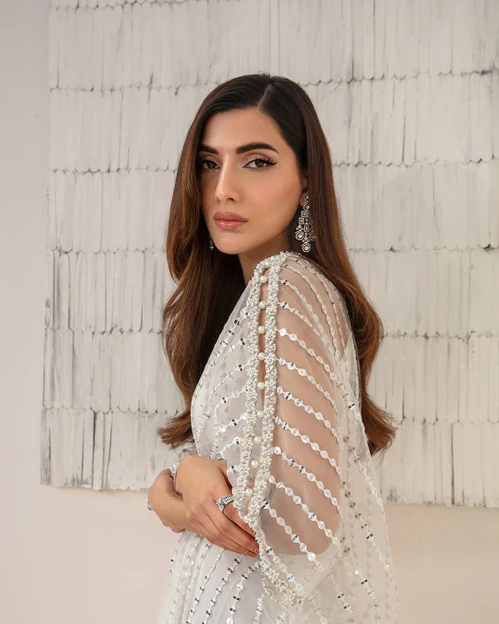 Model wearing an elegant white Ariella dress from Faiza Saqlain's Lenora Luxury Pret '24 collection. Pakistani clothes online in UK.