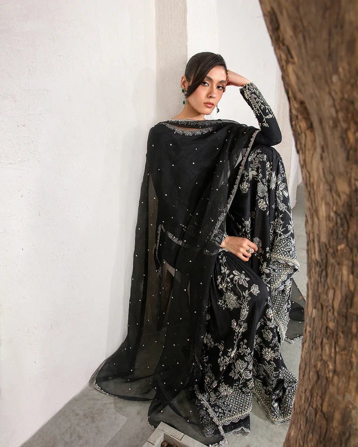 Model wearing a black Ciar dress from Faiza Saqlain's Lenora Luxury Pret '24 collection. Pakistani clothes online in UK.