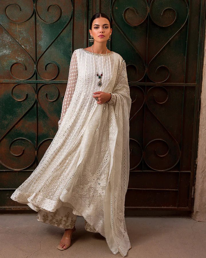 Model wearing an elegant white Aysel dress adorned with intricate detailing from Faiza Saqlain's Luxe Formals Laira collection. Pakistani clothes online in UK.