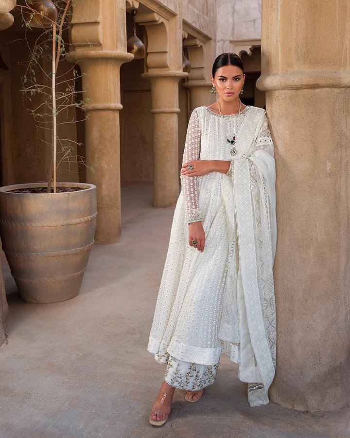 Model wearing an elegant white Aysel dress adorned with intricate detailing from Faiza Saqlain's Luxe Formals Laira collection. Pakistani clothes online in UK.