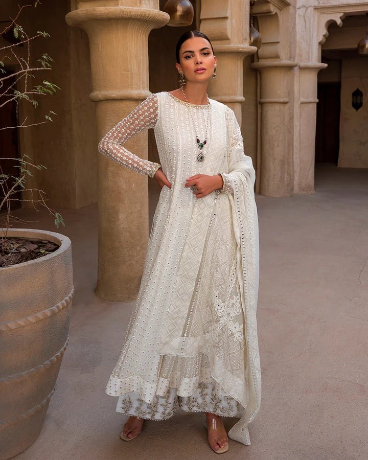 Model wearing an elegant white Aysel dress adorned with intricate detailing from Faiza Saqlain's Luxe Formals Laira collection. Pakistani clothes online in UK.