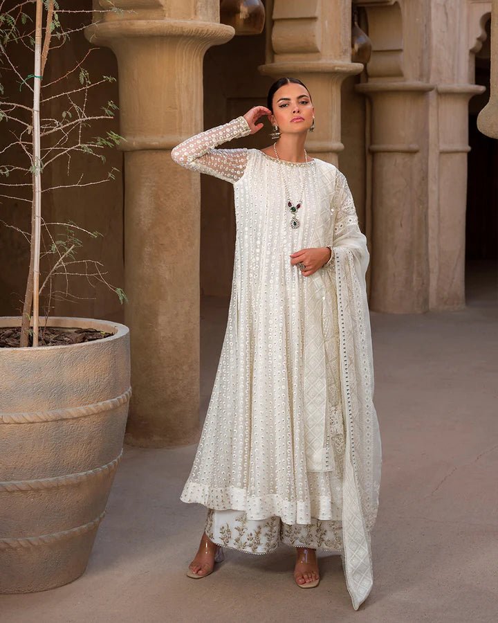 Model wearing an elegant white Aysel dress adorned with intricate detailing from Faiza Saqlain's Luxe Formals Laira collection. Pakistani clothes online in UK.