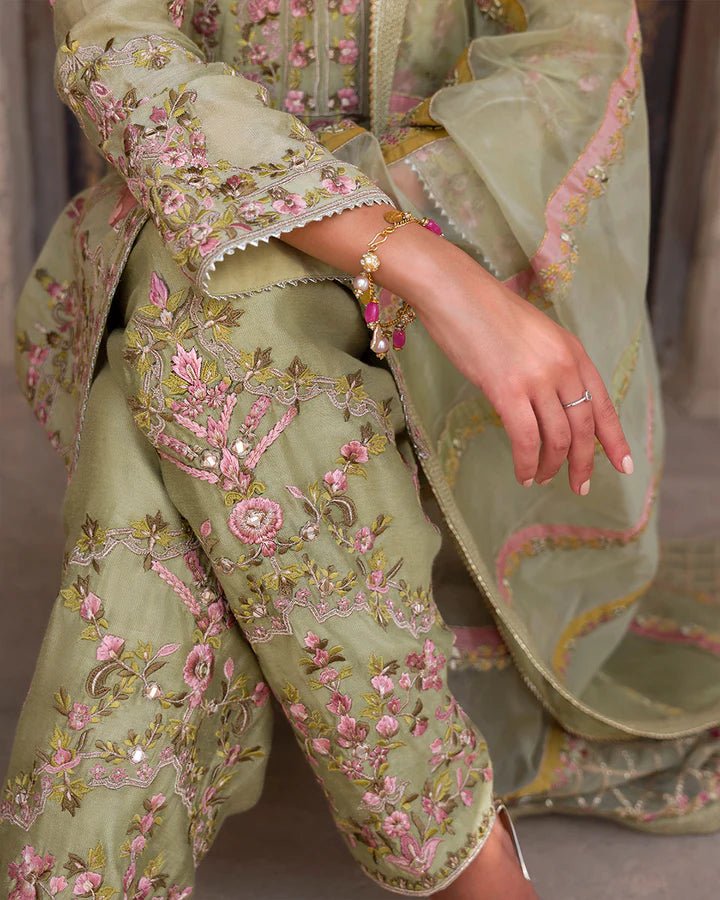 Model wearing a delicate green Noya dress adorned with floral embroidery from Faiza Saqlain's Luxe Formals Laira collection. Pakistani clothes online in UK.