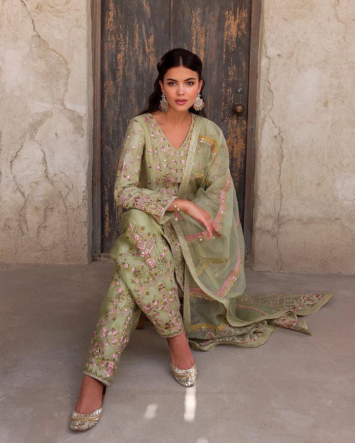 Model wearing a delicate green Noya dress adorned with floral embroidery from Faiza Saqlain's Luxe Formals Laira collection. Pakistani clothes online in UK.